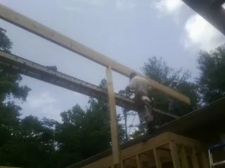 Carpenter setting a ridge beam over a new addition frame — Ice Dam Removal by Roofing Brothers in Pearl River