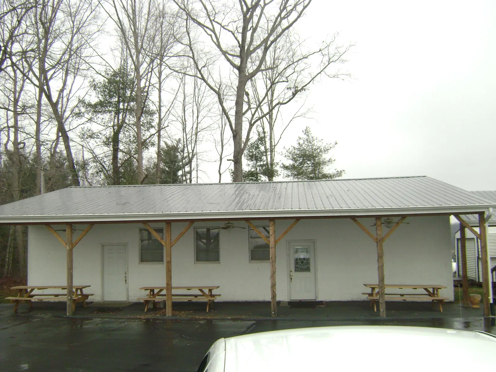 Gray metal roof over a block building with a timber post porch in Pearl River